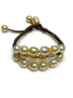 Bracelet with three rows of golden Australian pearls on hand-rolled leather, featuring an adjustable clasp with pearl detail.