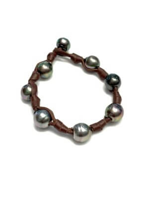 Bracelet with eight Tahitian pearls and bow accents on hand-rolled leather.