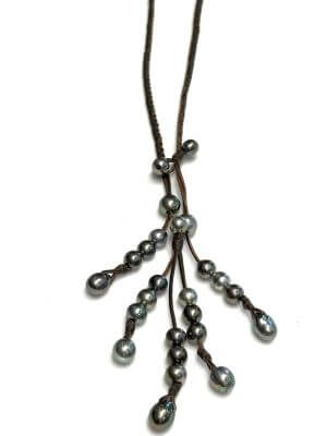 Braided necklace featuring 25 semi-baroque Tahitian pearls, mounted on hand-rolled kangaroo leather, embodying bold elegance and unisex design.