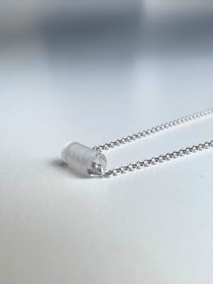 Delicate sterling silver necklace, 40 cm length, adjustable to 38 cm and 36 cm, with a 1.2 cm clear quartz charm; handcrafted from recycled materials, symbolizing clarity, renewal, and transformation.