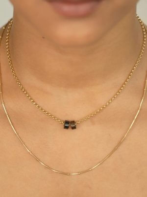 „Timeless 18K gold-plated sterling silver necklace, 48 cm length, adjustable to 46 cm and 44 cm, with two crystal donut pendants in onyx and smoky quartz; handcrafted from recycled materials, symbolizing grounding, clarity, and transformation.“