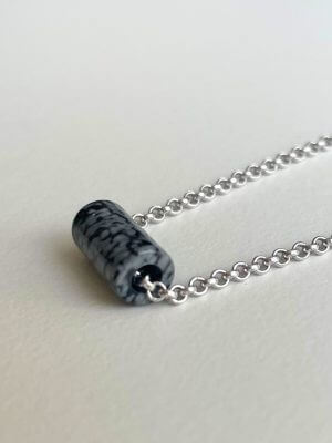 Delicate sterling silver necklace, 40 cm length, adjustable to 38 cm and 36 cm, with a 1.2 cm snowflake obsidian charm; handcrafted from recycled materials, symbolizing grounding, balance, and protection.