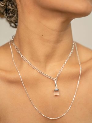 Close-up of a sterling silver necklace with a single chain, featuring a clear quartz charm and a sleek silver clip designed for interchangeable crystal charms.